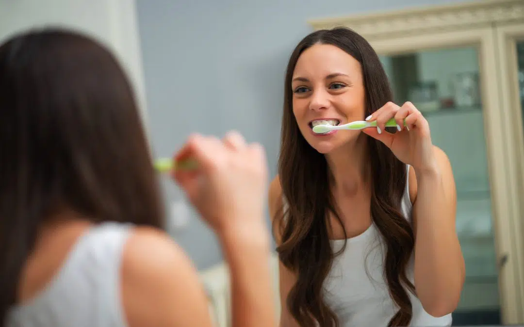 Woman brushing her teeth at home