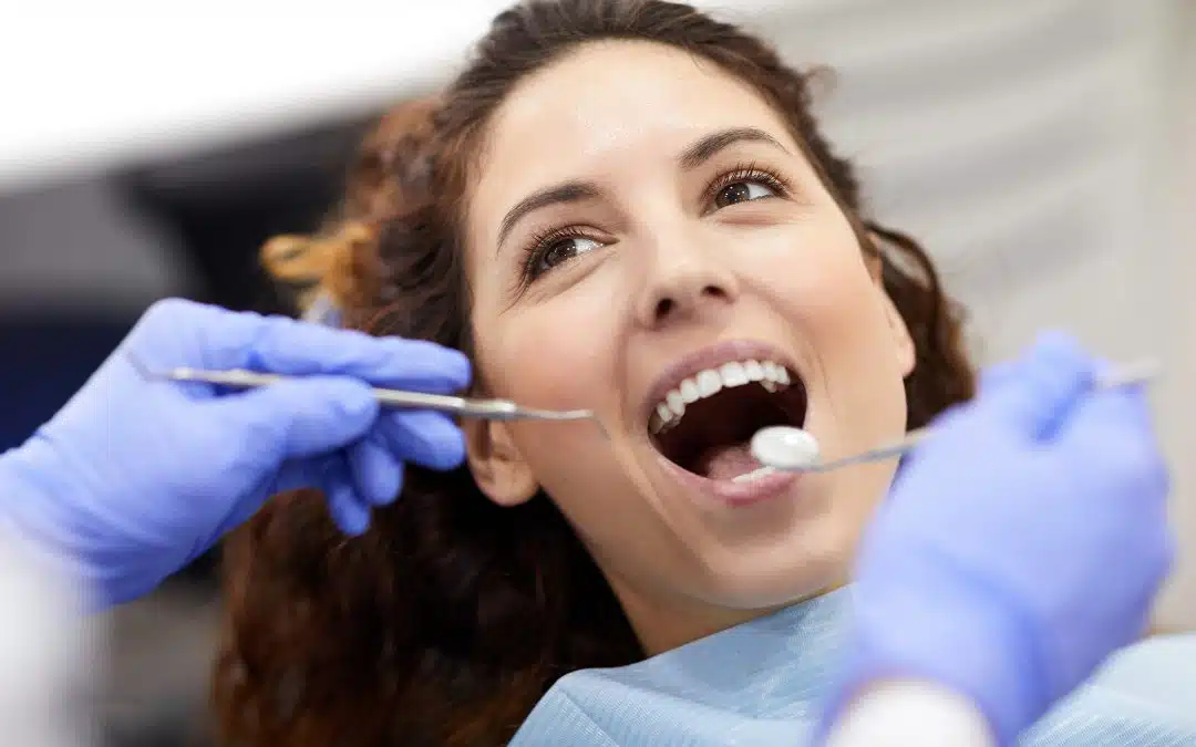 woman smiling getting teeth cleaned - Trail West Family Dentistry